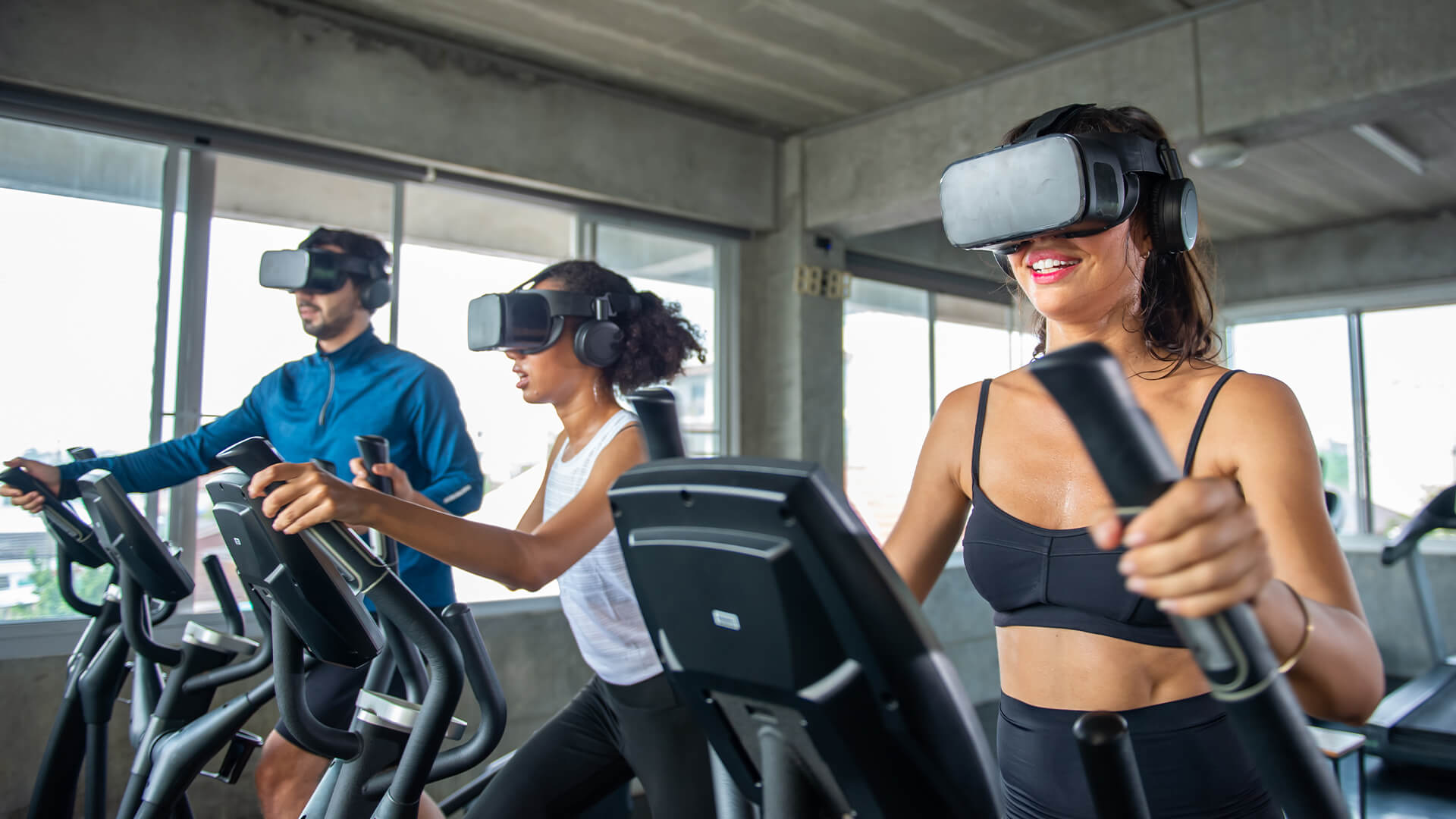 Healthy athletic man and woman wearing VR glasses workout exercise on cycling machine in virtual reality cyberspace at fitness gym.