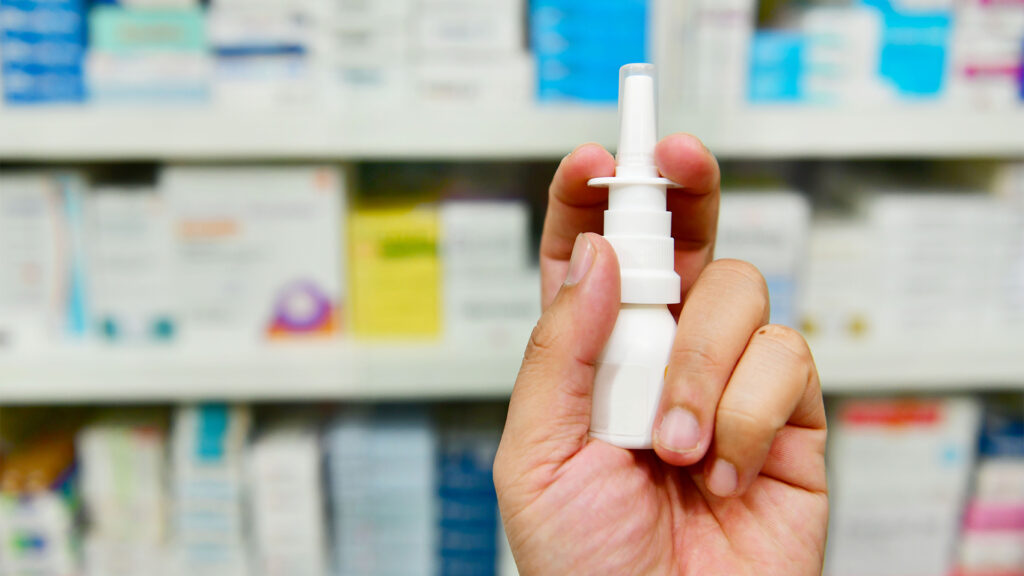Close up shot pharmacist holding nasal spray medicine at the drugstore